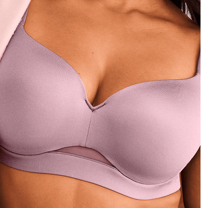A woman's chest is adorned with a light purple bra featuring a sheer mesh band, set against a soft pink fabric in the background.