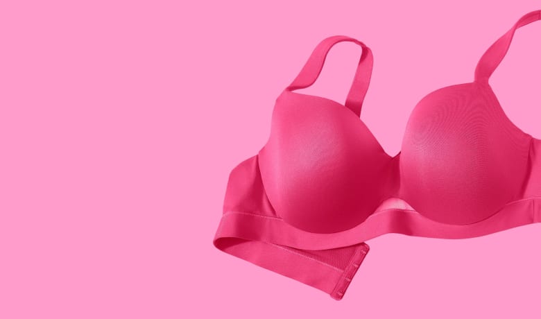 A bright pink bra rests on a solid pink background.