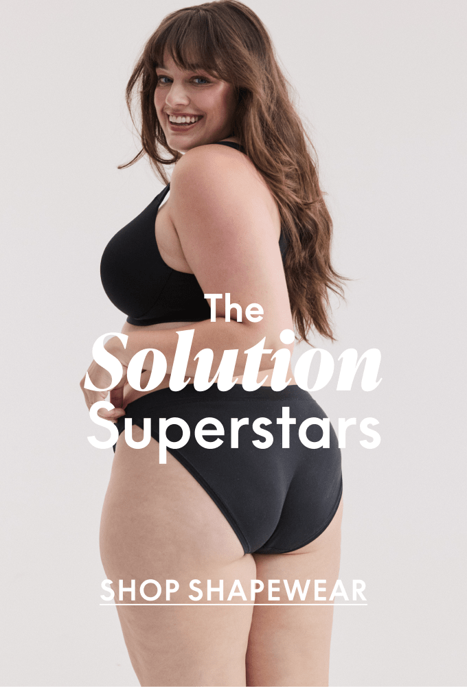 A smiling woman in black underwear poses against a plain background with text overlaying the image.