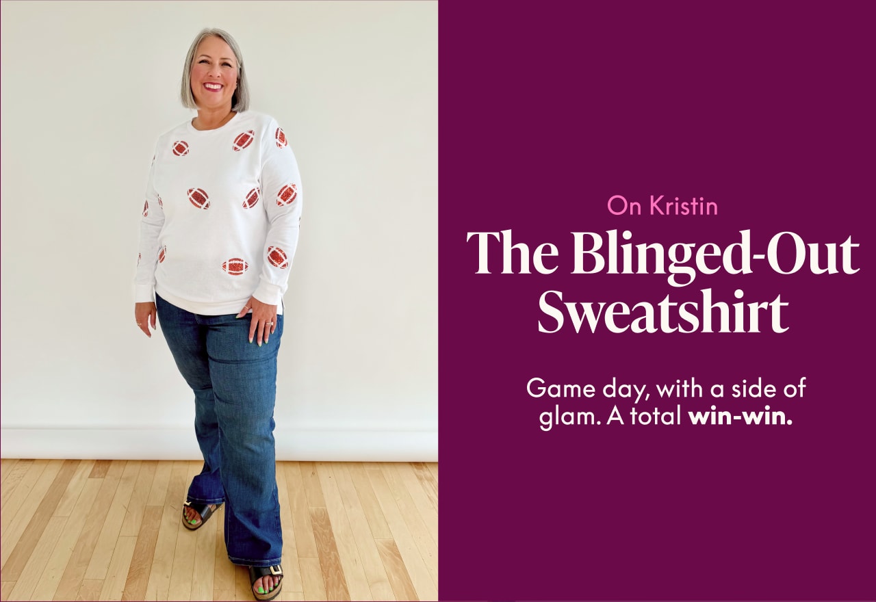 A woman in a white sweatshirt with footballs and jeans stands against a plain wall, with text on the right describing her outfit as 'The Blinged-Out Sweatshirt' for 'Game day, with a side of glam.'