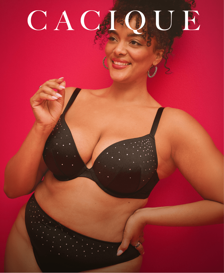 A smiling woman wearing a black sparkling lingerie set poses against a solid bright red background.