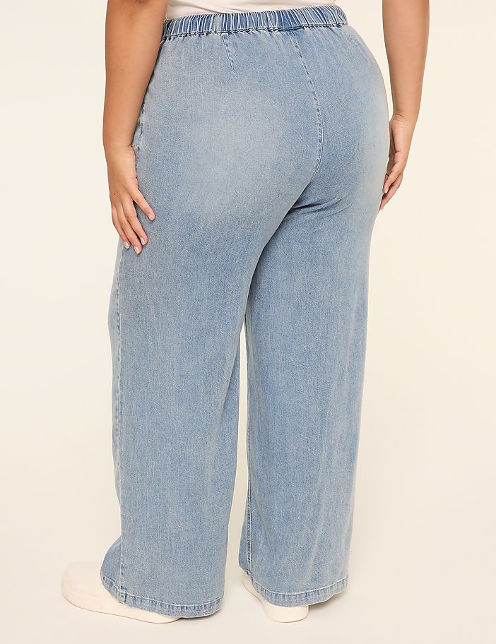 The image shows a pair of light blue denim pants with an elastic waistband, worn by a person's lower body.