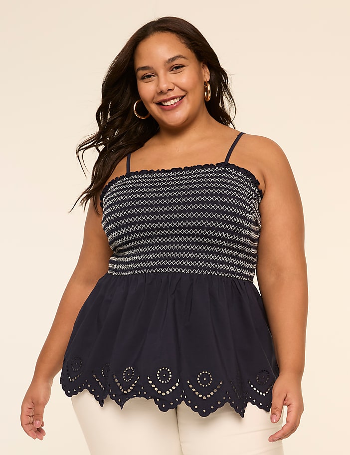 A smiling young woman wearing a black and white striped top with a scalloped hem stands against a plain beige background.