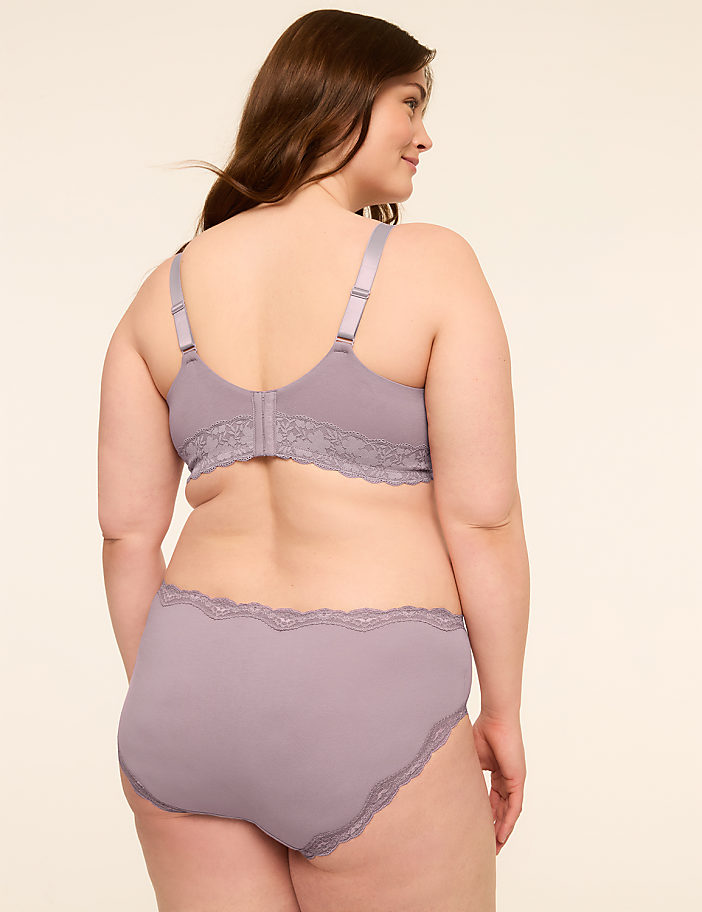 A woman in a lavender bra and matching underwear stands against a plain, light-colored background.