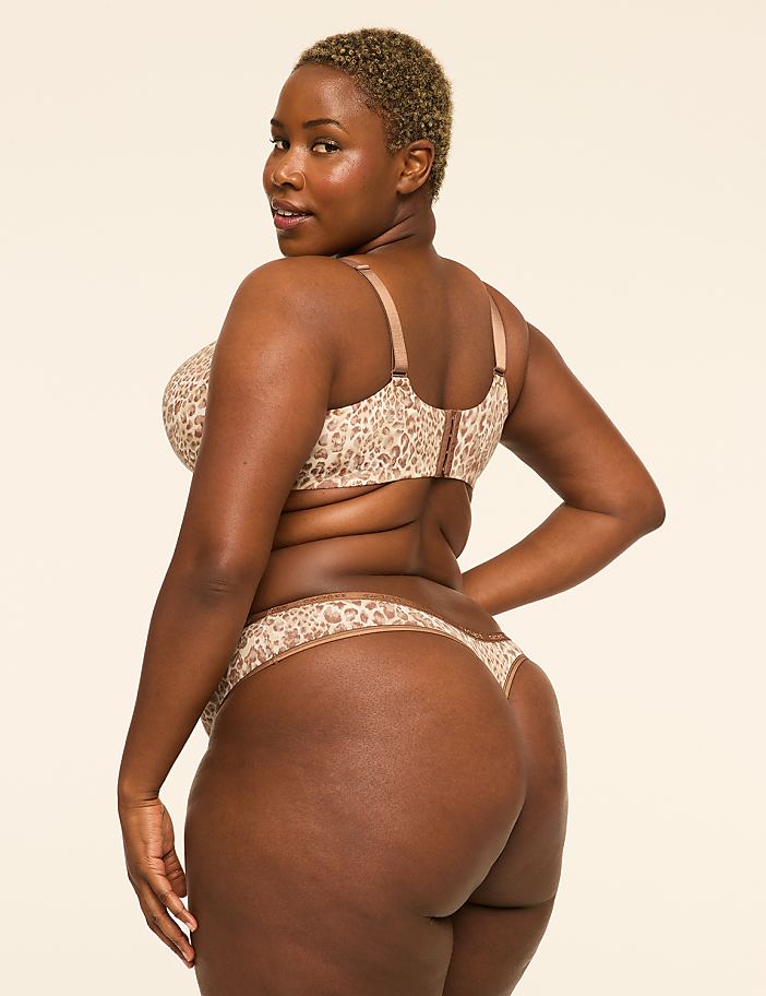A woman in a leopard print bra and thong poses against a plain, light-colored background.