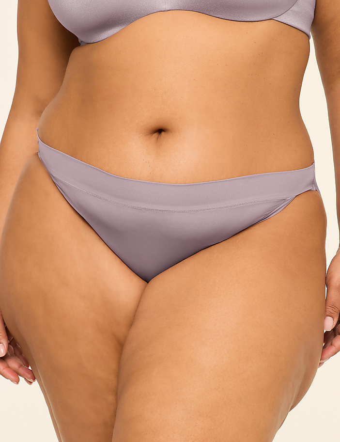 A close-up of a woman's torso in lavender underwear is set against a plain, light background.