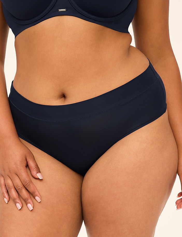 A close-up of a woman's torso in navy blue underwear is shown against a plain background.