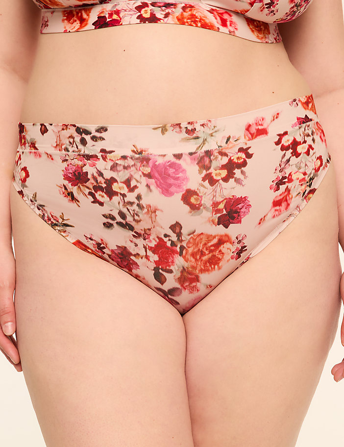 A close-up of a person wearing floral-patterned underwear with a plain background.