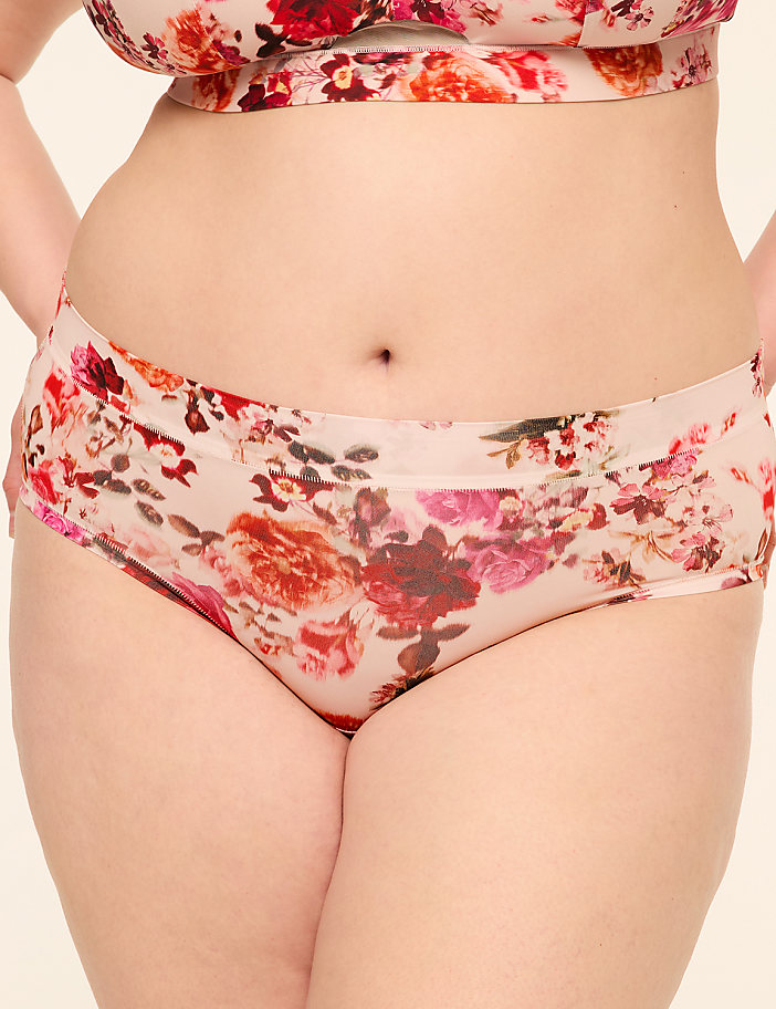 A person's midsection is shown in the foreground, wearing floral-patterned underwear, against a plain, light-colored background.