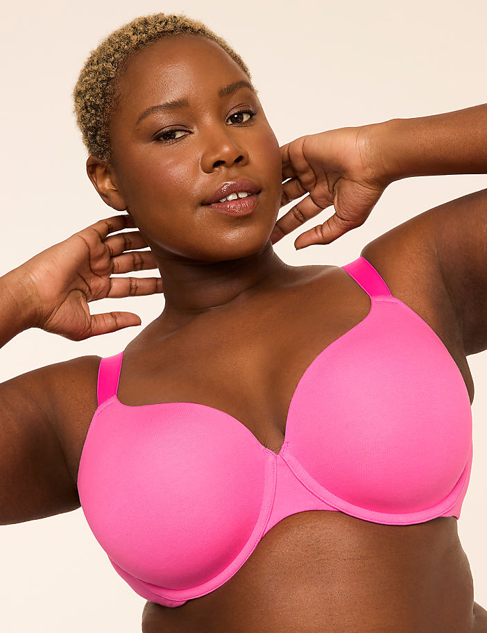 A woman in a bright pink bra and underwear stands with her back to the camera against a plain, light-colored background.