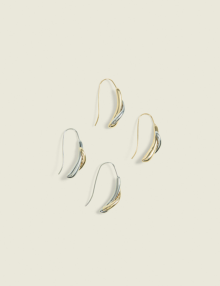 Four elegant, two-toned earrings with curved, layered designs are arranged in a diamond pattern against a soft, cream-colored background.