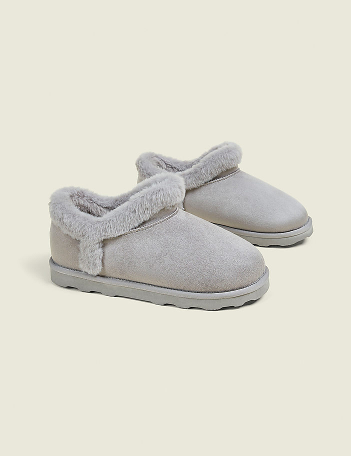 A pair of light gray, fuzzy-lined ankle boots rests on a plain, light gray background.