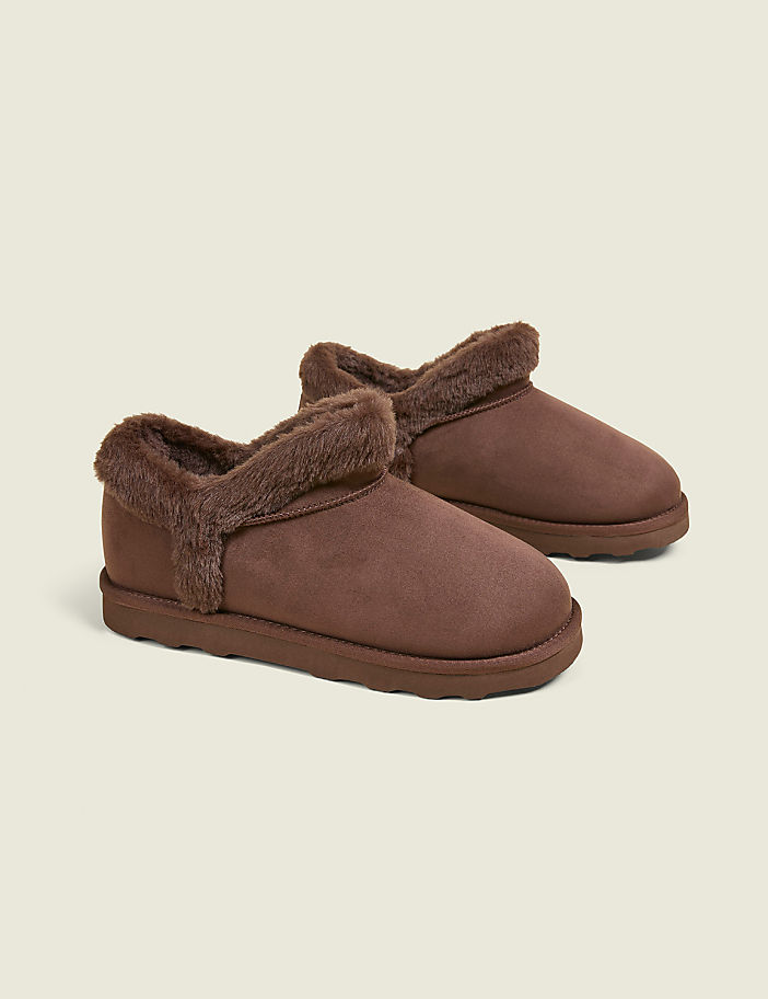 A pair of brown, fuzzy slippers rests on a plain, light gray background.