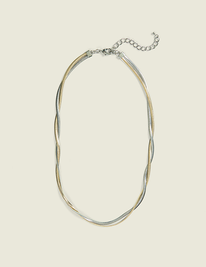A delicate, multi-strand necklace with silver and gold chains lies on a plain, light beige background.