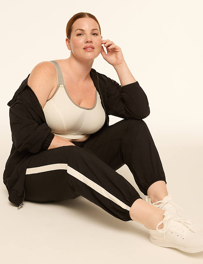 A woman in athletic wear poses on a plain background.