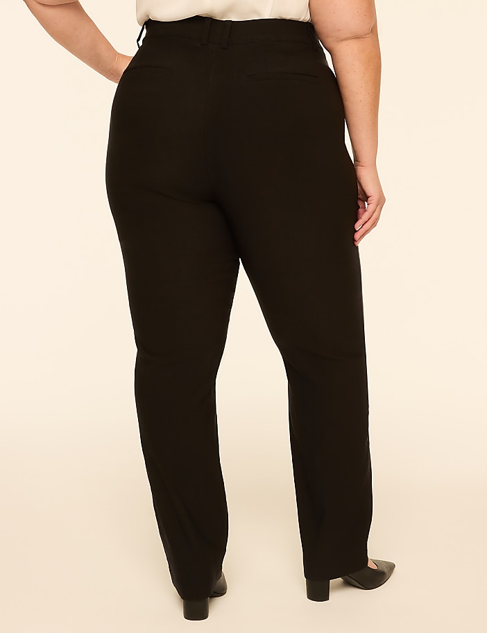 A person wearing black pants stands against a plain, light-colored background.