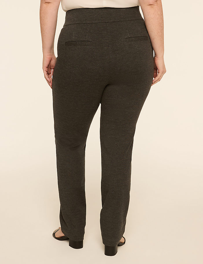 A person wearing dark gray pants stands against a plain, light-colored background.