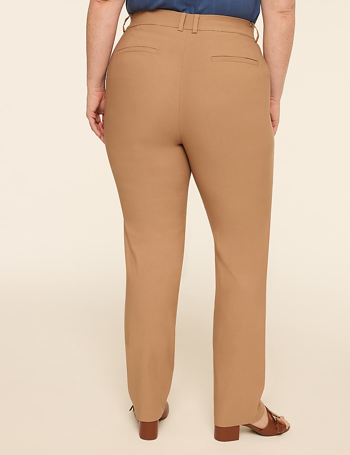 A person wearing tan pants stands against a plain, light-colored background.