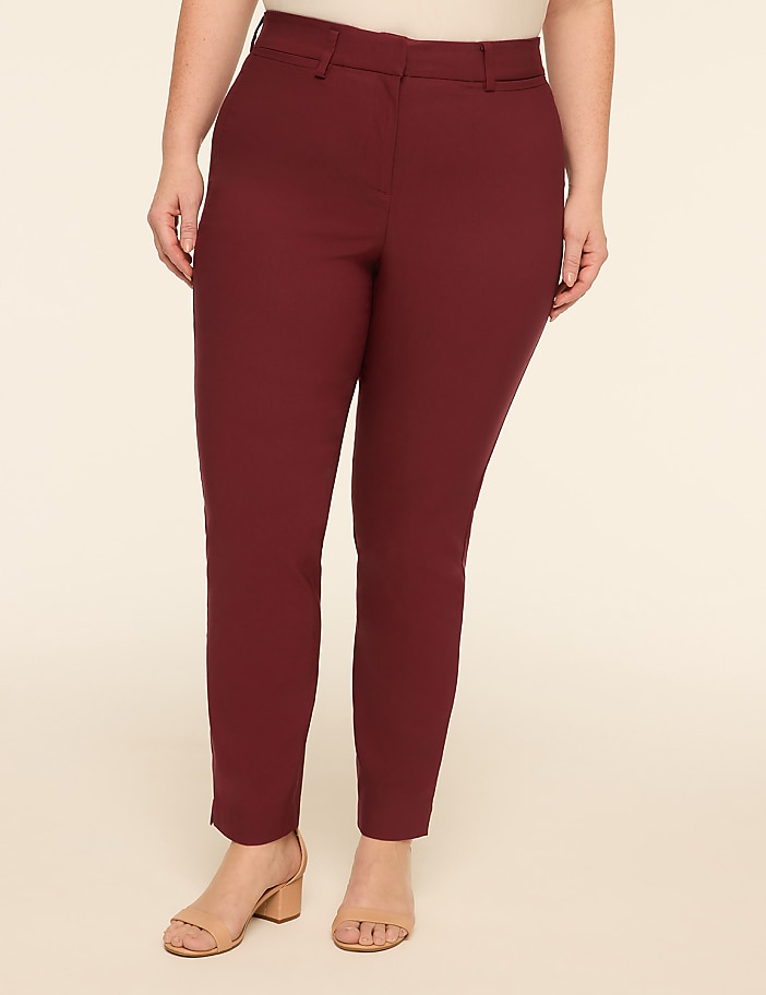 A person wearing maroon pants and tan sandals stands against a plain, light-colored background.