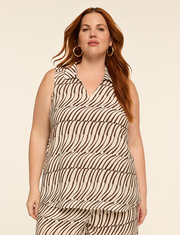 A woman with auburn hair and hoop earrings stands in the foreground against a plain, light-colored background.