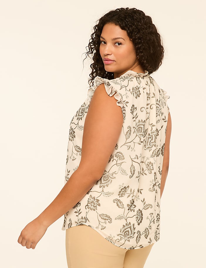 A woman with curly dark hair, wearing a floral print blouse, is shown from the side against a plain, light-colored background.