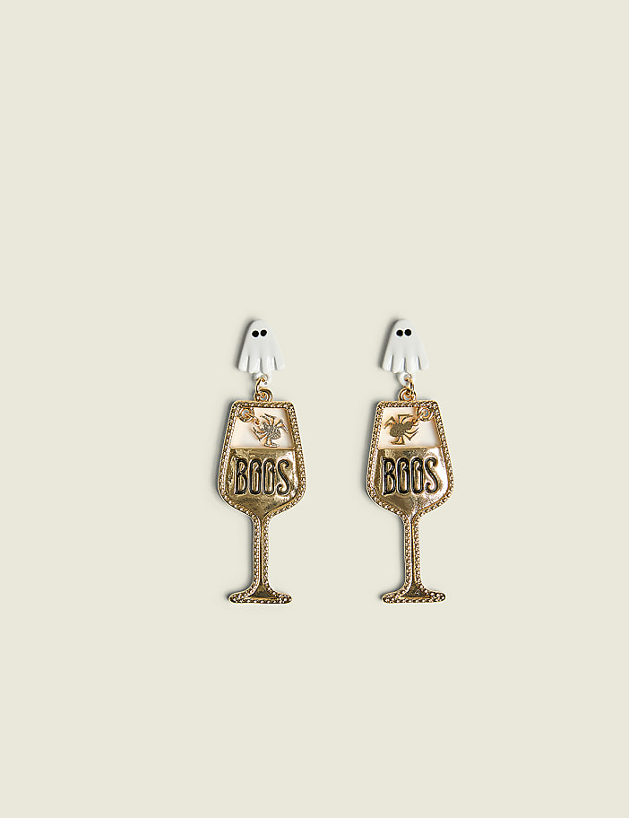 Two Halloween-themed wine glass earrings with ghost charms hang against a plain, light-colored background.