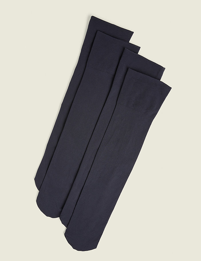 Four dark navy knee-high socks are neatly arranged on a plain, light beige background.