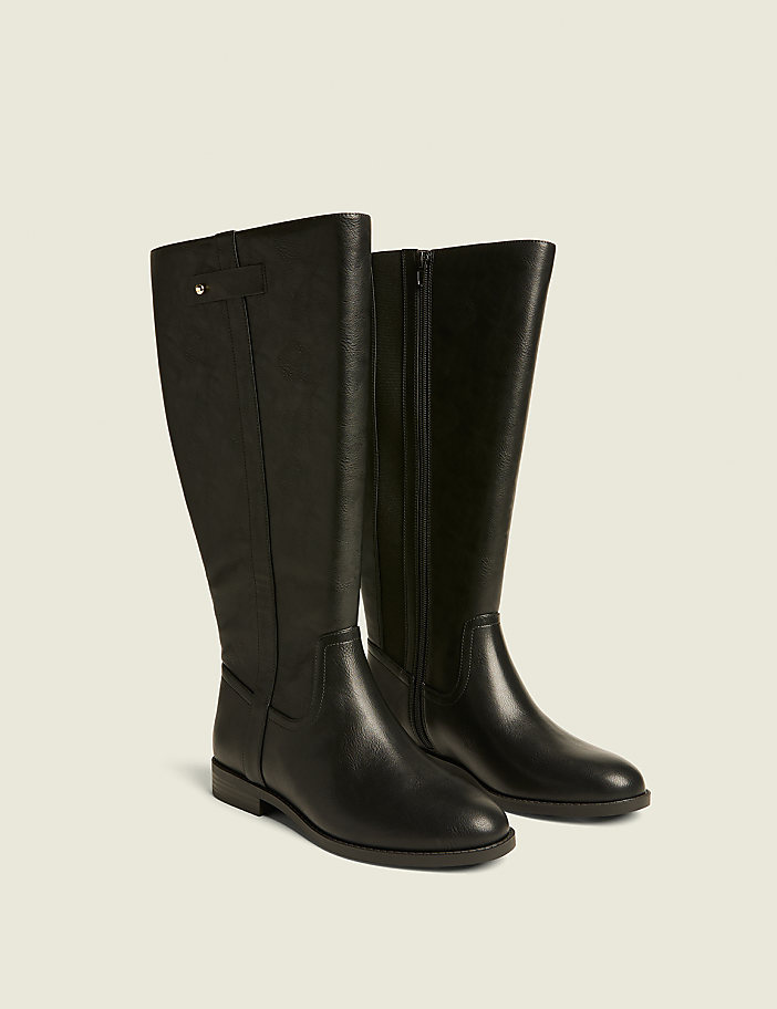 A pair of black leather knee-high boots with a side zipper and a small buckle detail are displayed against a plain, light beige background.