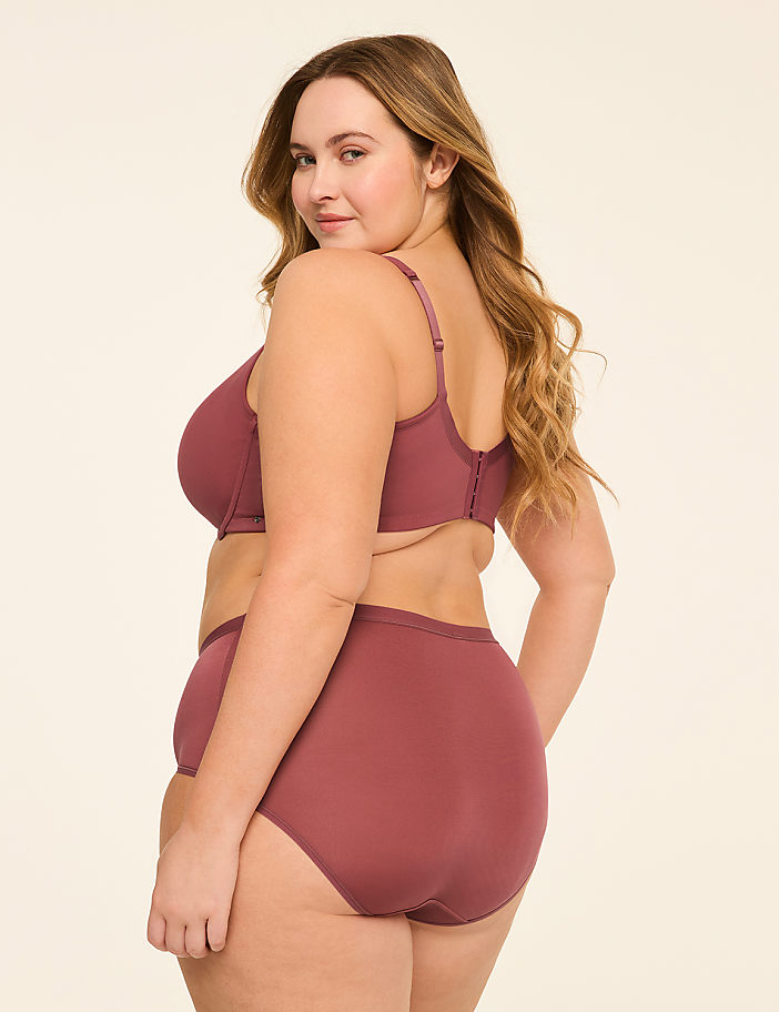 A woman in a mauve bra and underwear is shown from the side against a plain, light-colored background.