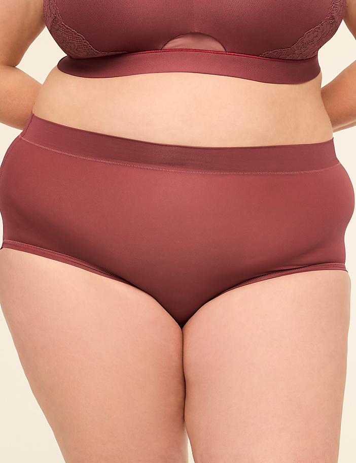 A person in maroon underwear stands against a plain, light-colored background.