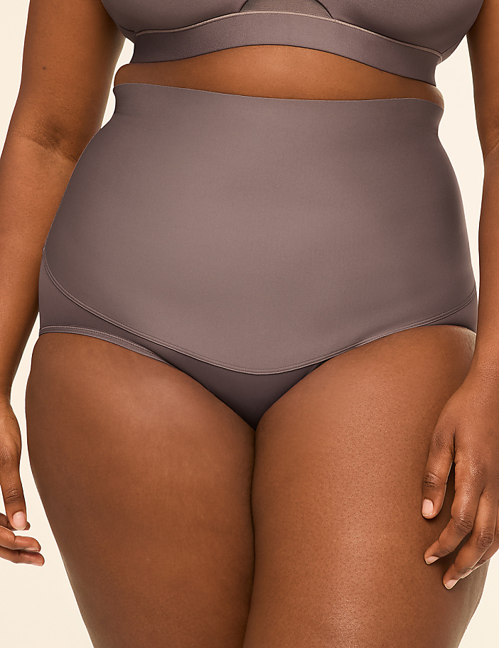 A woman's torso is shown from the waist down, wearing high-waisted briefs and a matching bra, against a plain, light background.