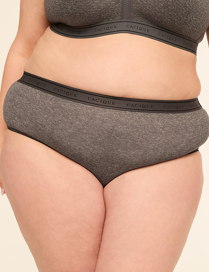 A person in grey underwear with the brand name "Cacique" visible on the waistband stands against a plain, light-colored background.