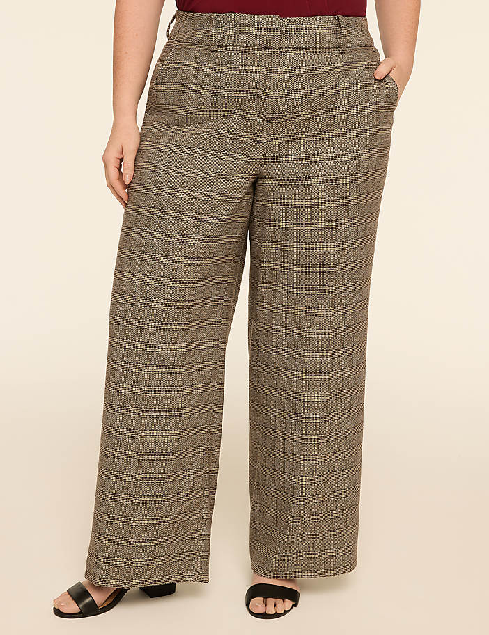 A person wearing wide-leg patterned pants stands against a plain, light-colored background.