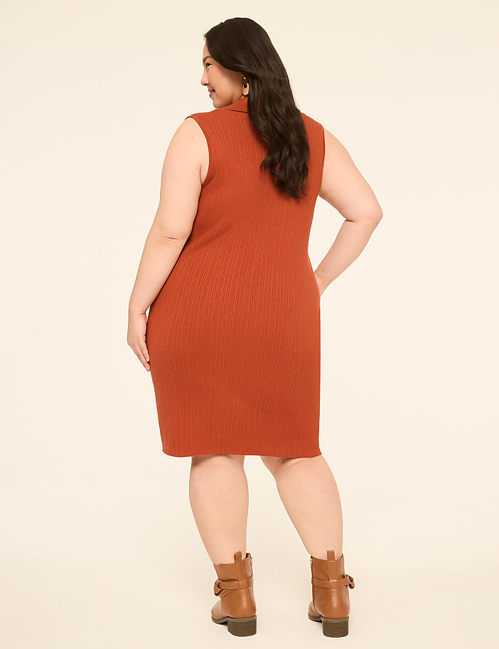 A woman in a rust-colored ribbed dress and brown boots stands against a plain, light-colored background.