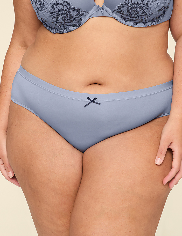 A woman's torso is shown from the waist up, wearing a light blue bra with lace detailing and matching bikini-style underwear with a small dark blue bow in the front.