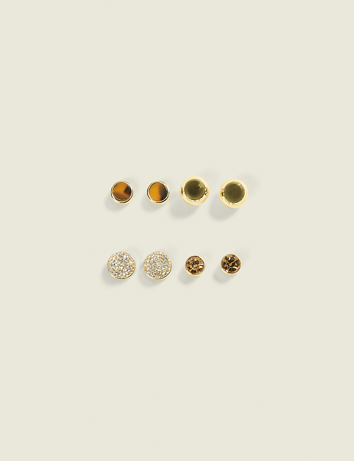 Four pairs of earrings, featuring a mix of gold, tiger's eye, and crystal designs, are arranged on a plain, light-colored background.