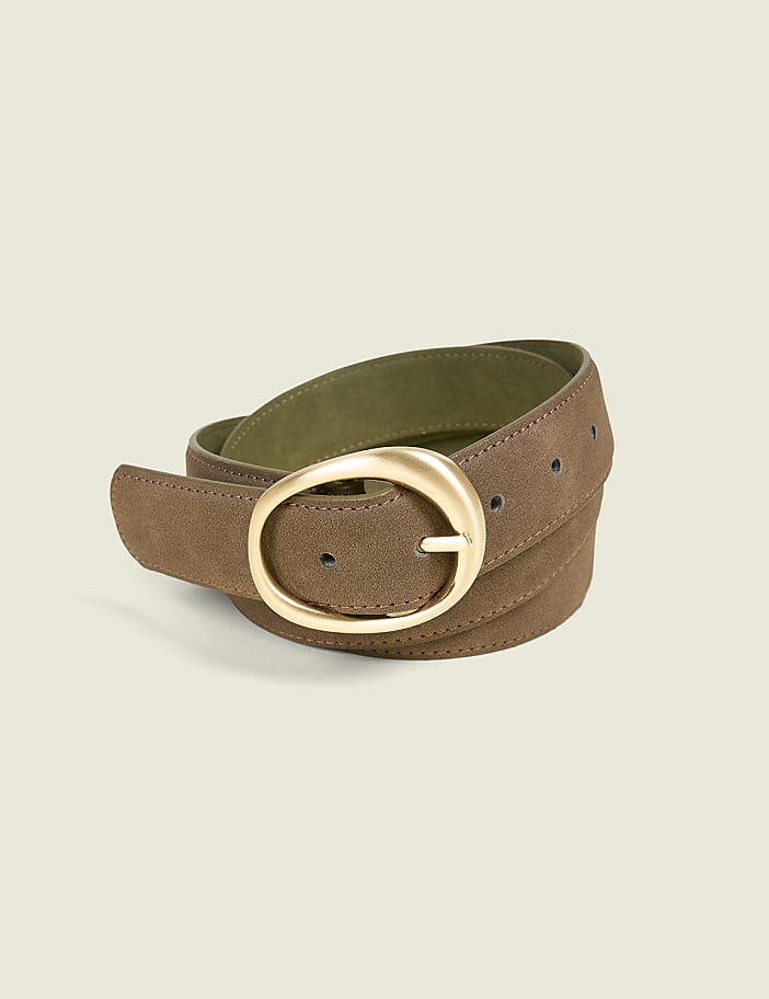 A brown suede belt with a gold oval buckle is coiled on a plain, light green background.