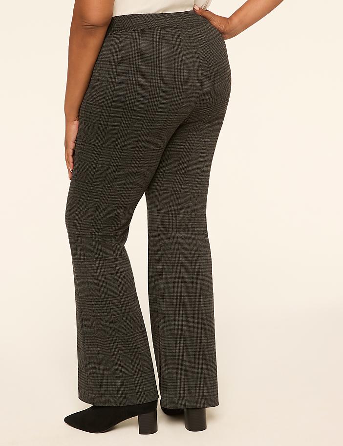 A person wearing plaid flared pants stands against a plain, light-colored background.