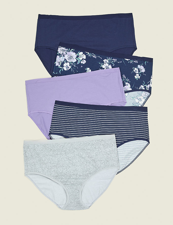 Five pairs of women's underwear, featuring floral, striped, and solid patterns, are neatly stacked against a plain, light brown background.