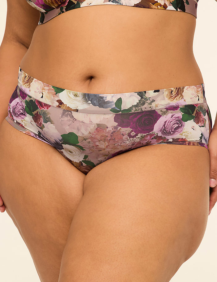 A close-up of a person wearing floral-patterned underwear, with a plain background.