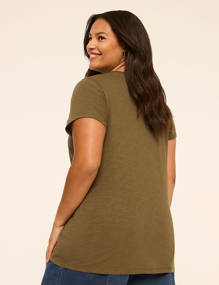 A smiling woman in a green t-shirt is shown from the back against a plain, light-colored background.