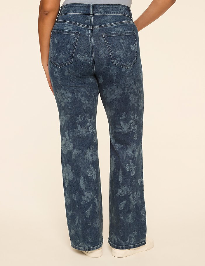 A person wearing floral-patterned denim jeans stands against a plain, light-colored background.