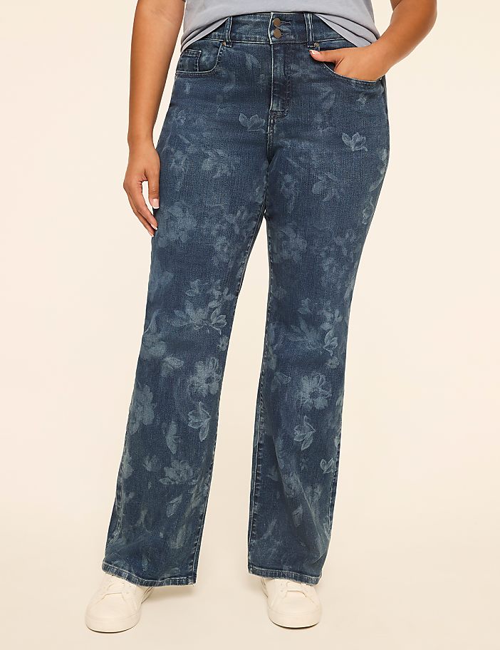 A person stands in the foreground wearing flared jeans with a subtle floral pattern, against a plain, light-colored background.