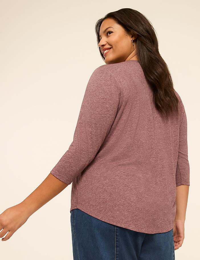 A woman in a mauve top and blue jeans is shown from the back, with a plain, light-colored background.