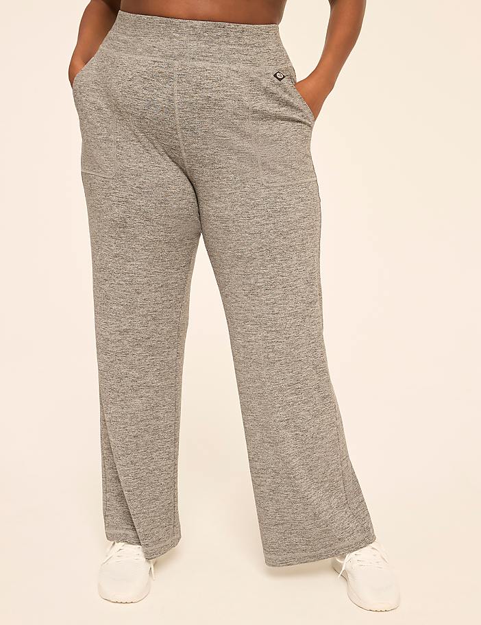 A person stands in heather gray sweatpants and white sneakers against a plain, light-colored background.