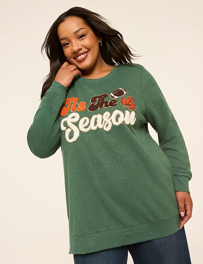A smiling woman in a green sweatshirt with "It's The Season" and sports graphics stands against a plain, light-colored background.