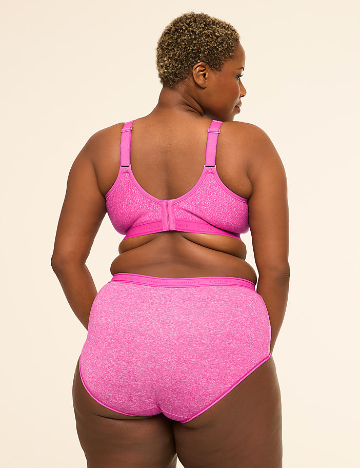 A woman with short, curly hair is shown from behind, wearing a pink bra and matching underwear against a plain, light-colored background.