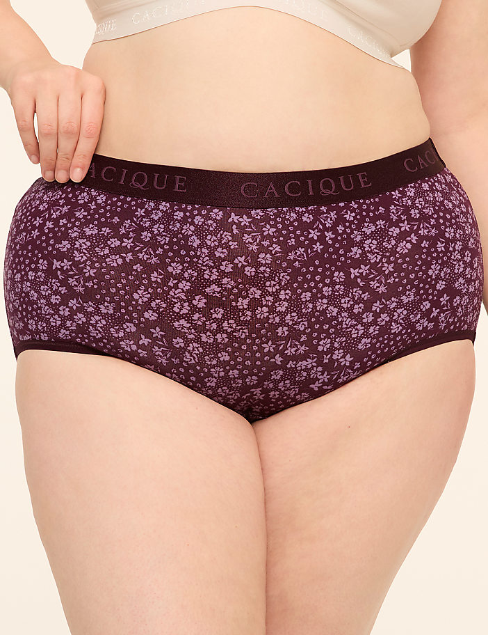 A person wears purple floral underwear with a plain background.