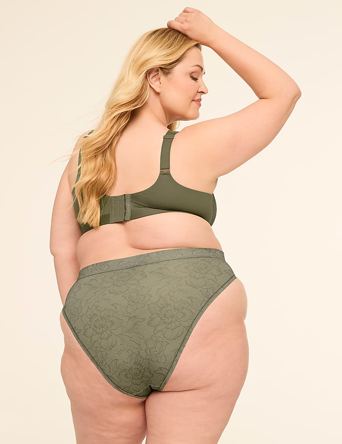 A woman in olive green lingerie stands with her back to the camera against a plain, light-colored background.