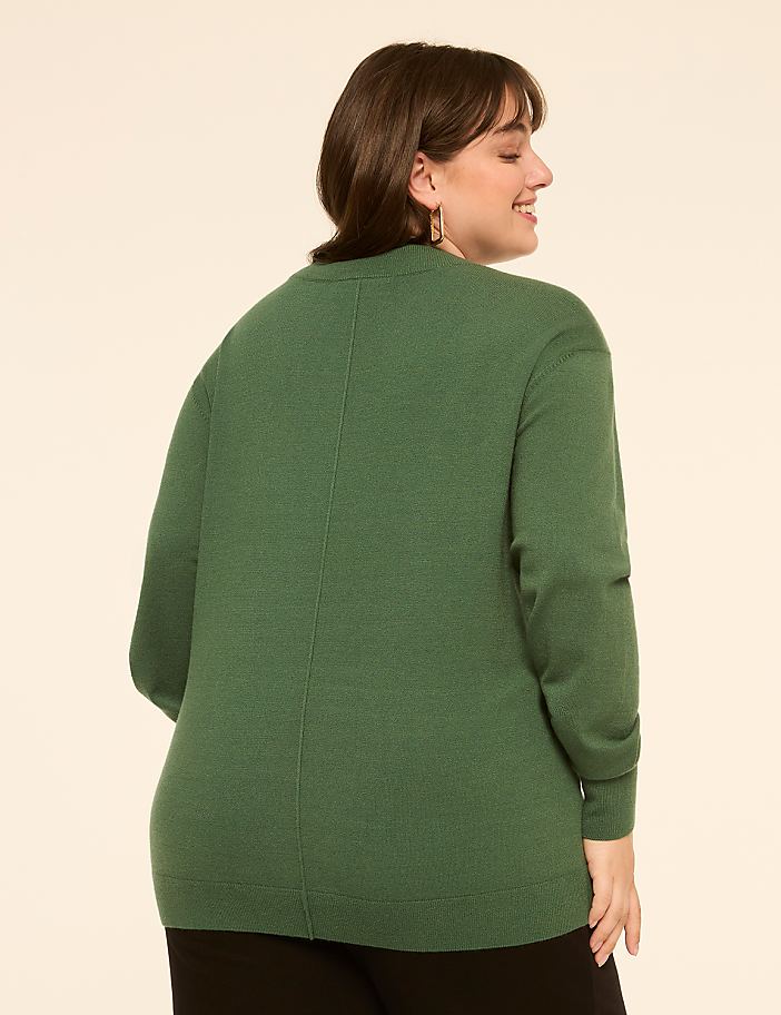 A woman in a green sweater is shown from the back, smiling, against a plain, light-colored background.